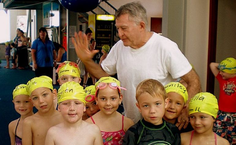 Laurie Lawrence congratulates Centaur swimmers with a group high five. Photo: Contributed